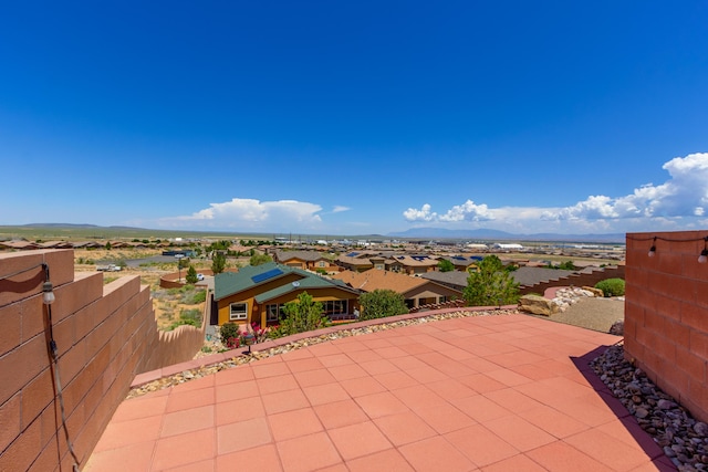 view of patio featuring a residential view, a mountain view, and fence