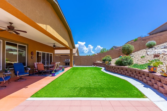 view of yard featuring ceiling fan and a patio area