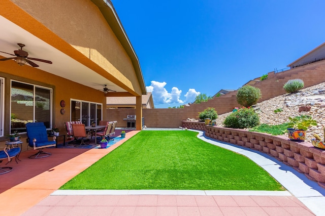 view of yard featuring a patio, a ceiling fan, and a fenced backyard