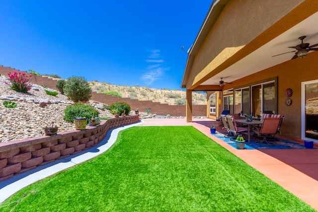 view of yard with a mountain view, a patio, and ceiling fan