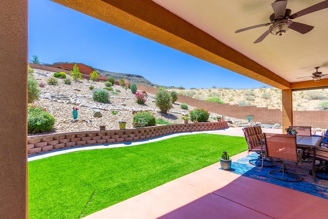 view of patio / terrace featuring a mountain view, ceiling fan, a fenced backyard, and outdoor dining area