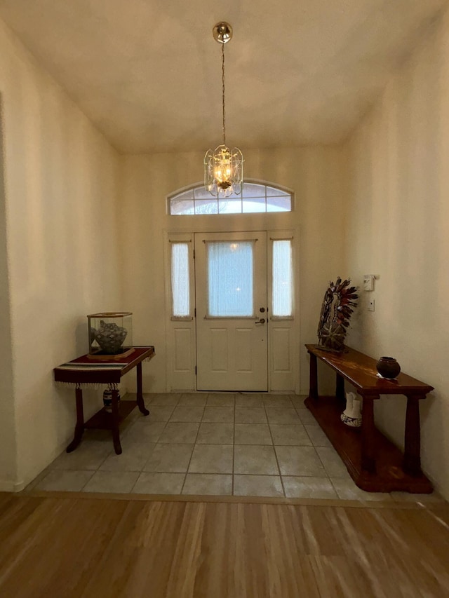 entryway with light wood-type flooring and a chandelier