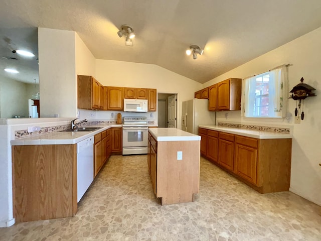 kitchen with lofted ceiling, sink, white appliances, a center island, and kitchen peninsula