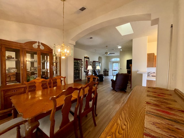 dining area featuring ceiling fan with notable chandelier and hardwood / wood-style floors