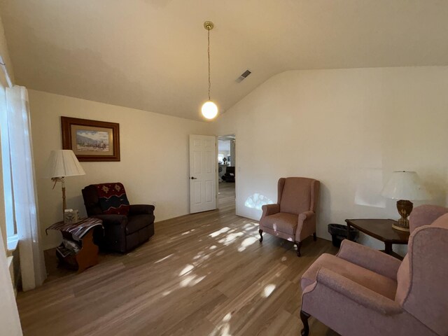 living area featuring hardwood / wood-style flooring and lofted ceiling