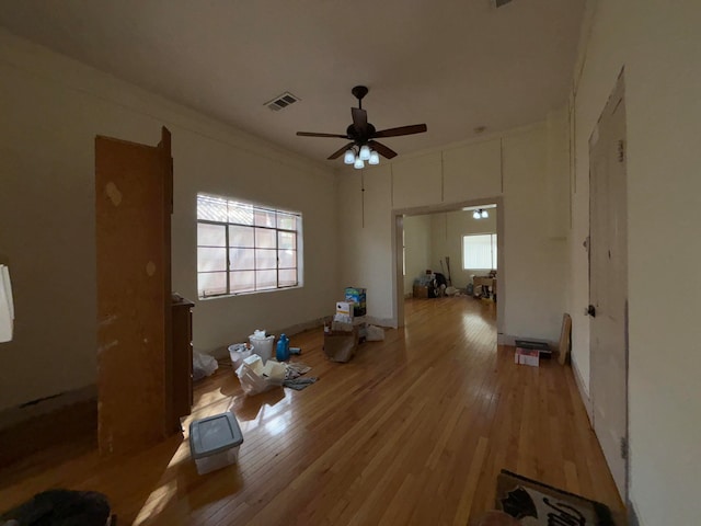 interior space featuring ornamental molding, ceiling fan, and light hardwood / wood-style flooring