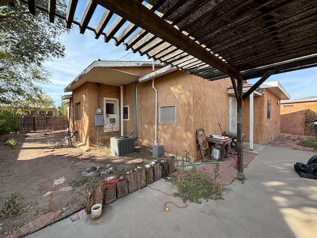 exterior space with central AC unit and a pergola