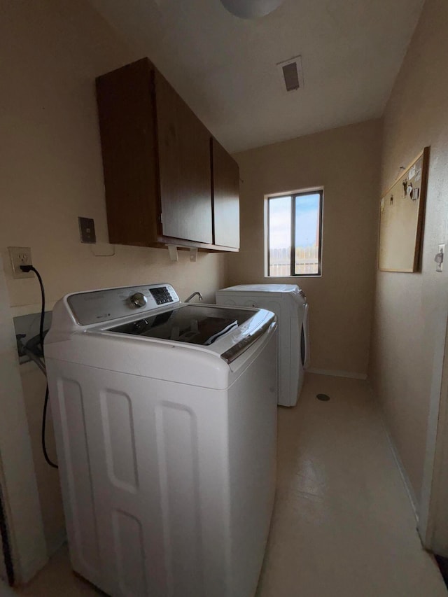 washroom with washing machine and dryer and cabinets