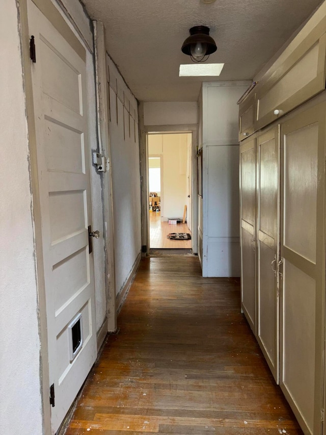 corridor featuring dark hardwood / wood-style flooring and a textured ceiling