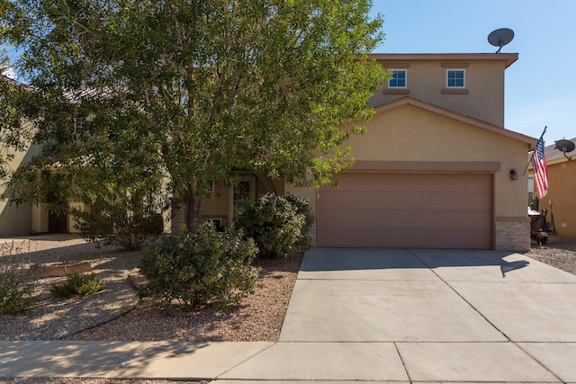 view of front facade featuring a garage, concrete driveway, stone siding, and stucco siding