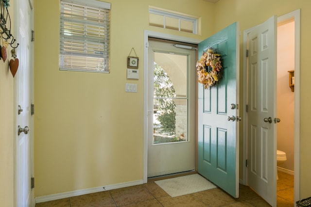 doorway to outside with light tile patterned flooring