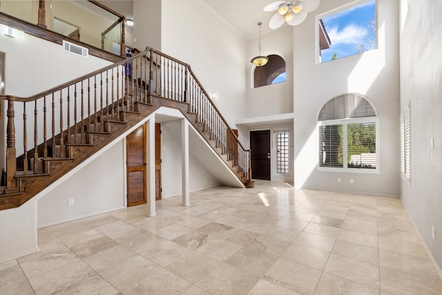 entrance foyer with a towering ceiling and ceiling fan