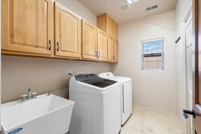 washroom with washer and clothes dryer, light tile patterned flooring, cabinets, and sink