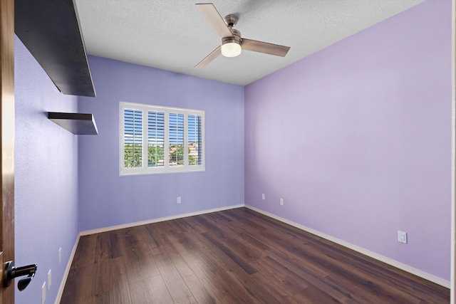 empty room featuring ceiling fan, dark hardwood / wood-style flooring, and a textured ceiling