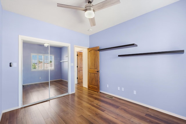 unfurnished bedroom with dark hardwood / wood-style flooring, a closet, and ceiling fan