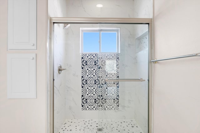 bathroom with a shower with door