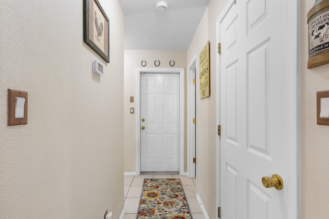 entryway with light tile patterned flooring and a textured ceiling