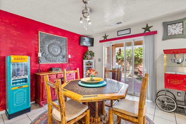 tiled dining space with a textured ceiling