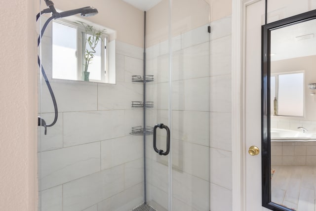 bathroom with independent shower and bath and a healthy amount of sunlight