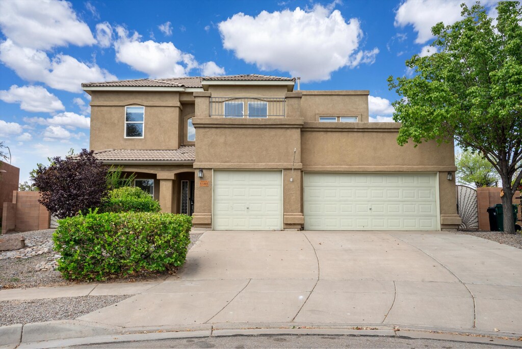 1501 Via Verane Dr SE, Rio Rancho, NM 87124 - view of front of house with concrete driveway, a tile roof, fence, stucco siding, and a balcony