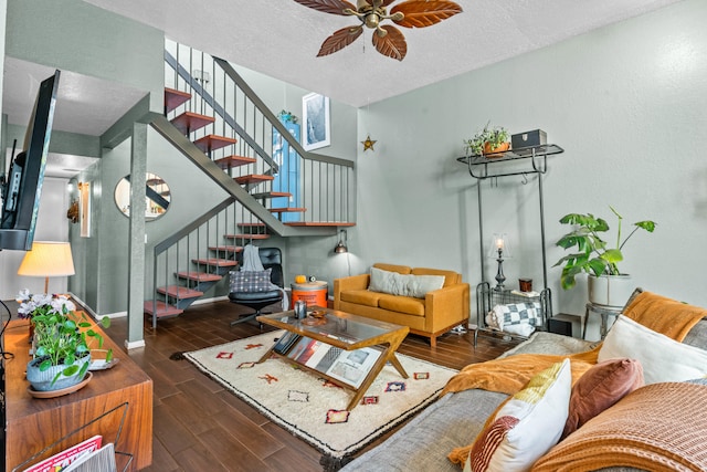 living room with dark wood-type flooring, a textured ceiling, and ceiling fan