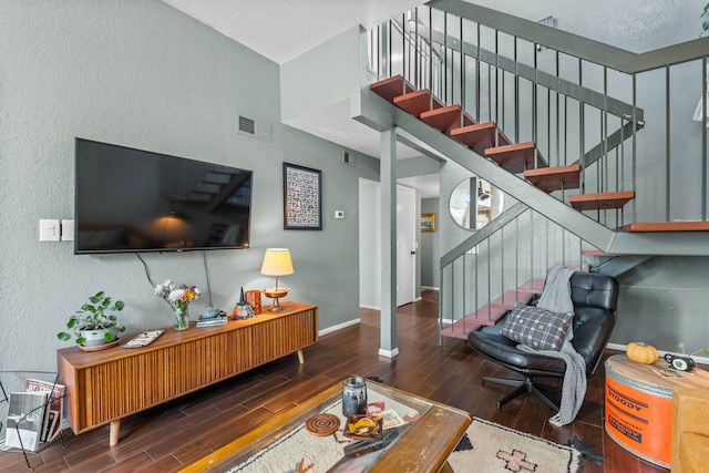 living room featuring a textured ceiling and dark hardwood / wood-style flooring