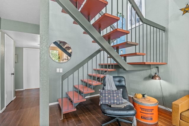 stairway featuring a wealth of natural light and hardwood / wood-style flooring