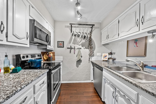 kitchen featuring sink, a textured ceiling, stainless steel appliances, white cabinets, and dark hardwood / wood-style floors