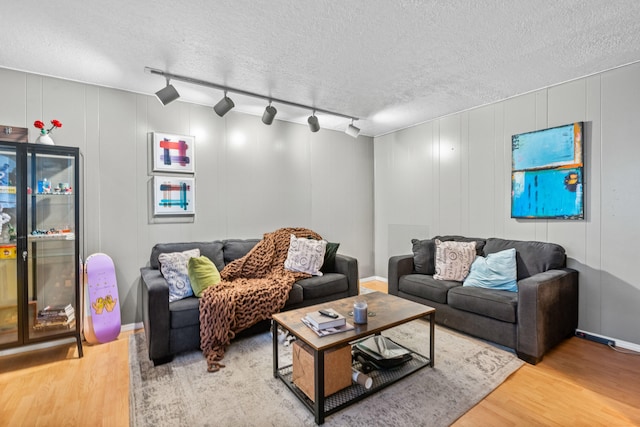 living room featuring hardwood / wood-style flooring, a textured ceiling, and track lighting