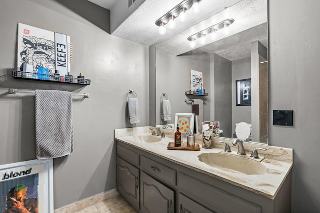 bathroom with vanity, a textured ceiling, and tile patterned flooring