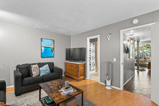 living room featuring a textured ceiling and light wood-type flooring