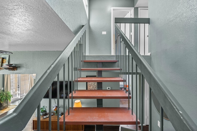 staircase with a textured ceiling