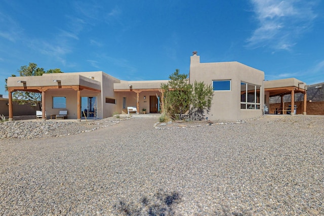 pueblo revival-style home featuring a patio area