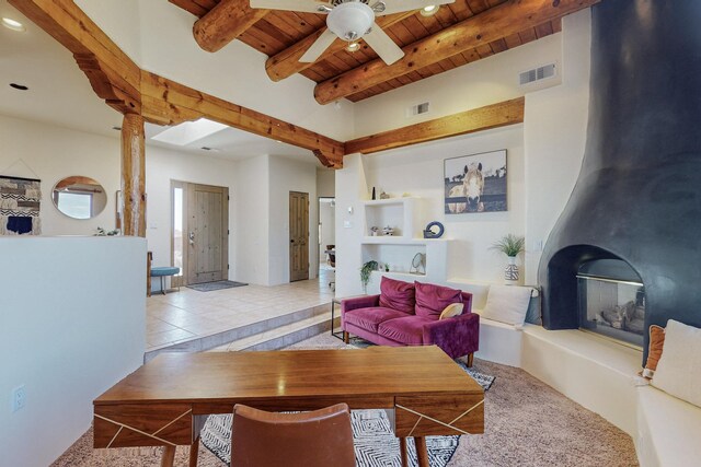 tiled living room with ceiling fan, beam ceiling, and wood ceiling