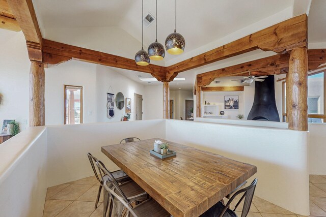 dining room with a wood stove, ceiling fan, plenty of natural light, and light tile patterned floors