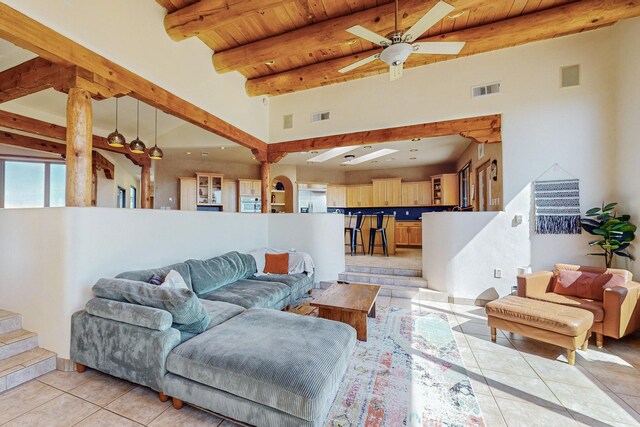 tiled living room with beam ceiling, a towering ceiling, ceiling fan, and wooden ceiling