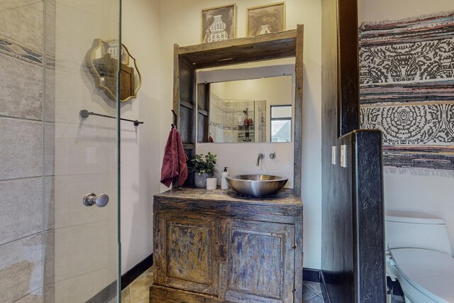 bathroom featuring a tile shower, vanity, and toilet