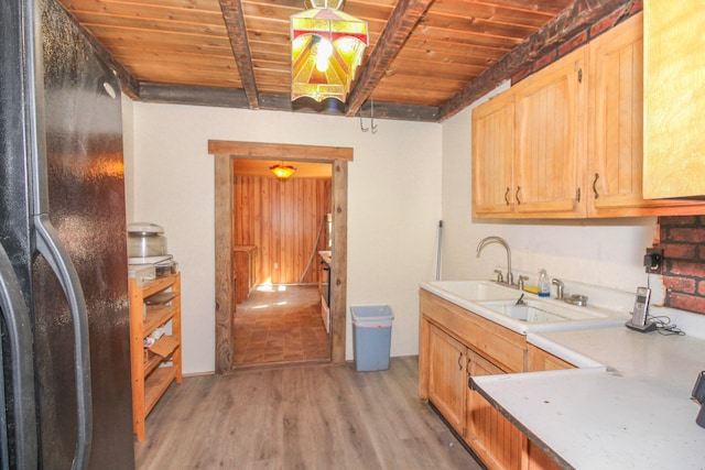 kitchen featuring light wood-type flooring, beamed ceiling, refrigerator, sink, and wooden ceiling