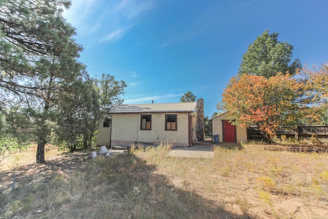 back of property featuring a storage unit