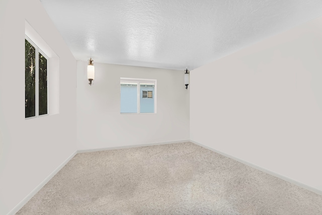 carpeted spare room featuring a textured ceiling