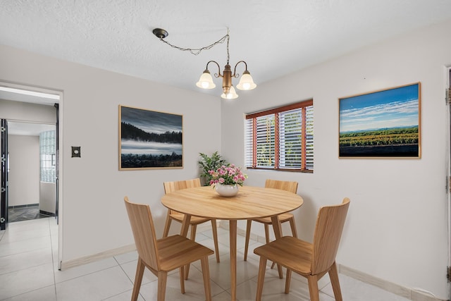 dining area featuring light tile patterned flooring, an inviting chandelier, and a textured ceiling