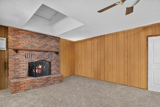 unfurnished living room featuring light carpet, wooden walls, and a textured ceiling