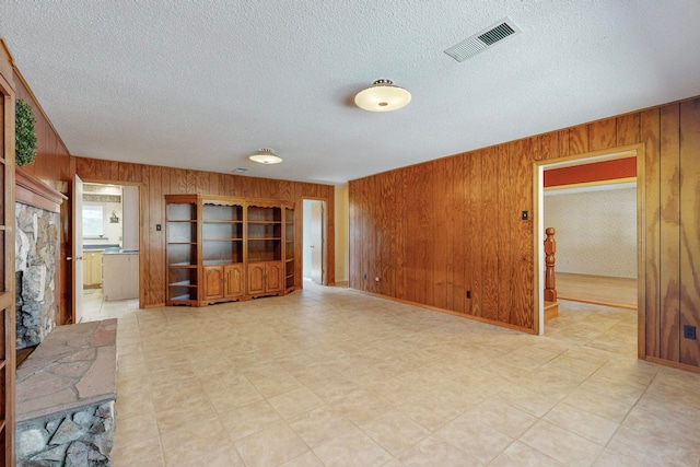 living room featuring a textured ceiling and wooden walls