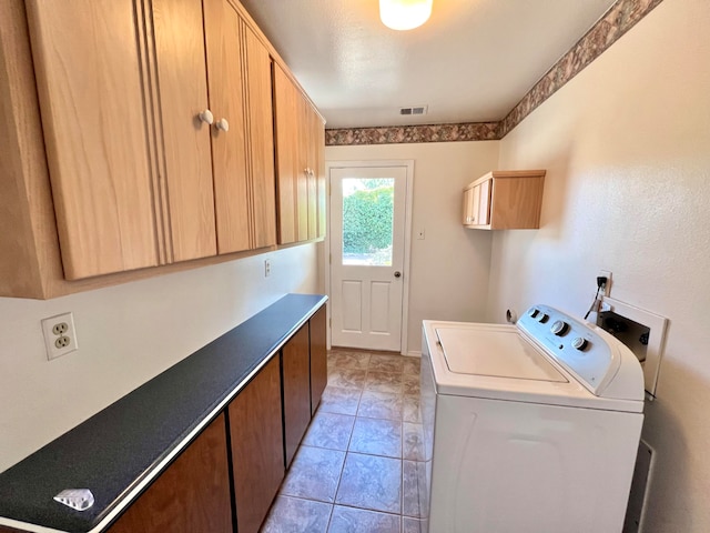 laundry room featuring cabinets, washer / dryer, and light tile patterned flooring