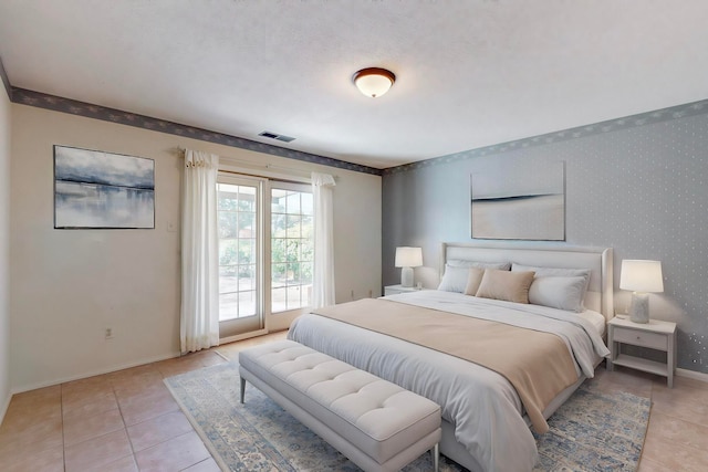 bedroom with light tile patterned floors and access to exterior