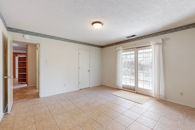 tiled spare room with a textured ceiling