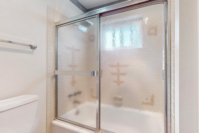 bathroom with bath / shower combo with glass door and toilet