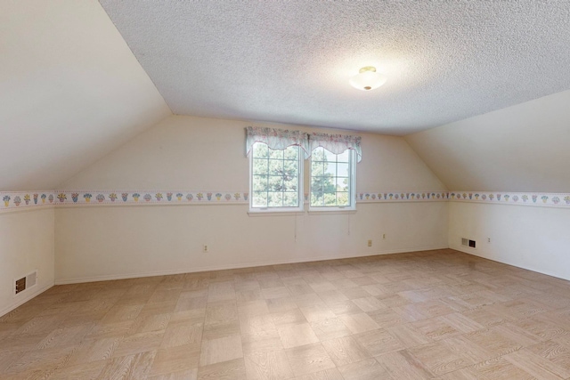 bonus room featuring a textured ceiling and lofted ceiling