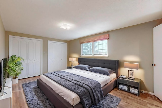 bedroom featuring multiple closets and light wood-type flooring