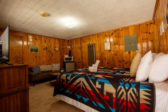 bedroom featuring wood walls, carpet flooring, and a textured ceiling